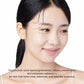 Woman with a cosmetic product on her face against a white background