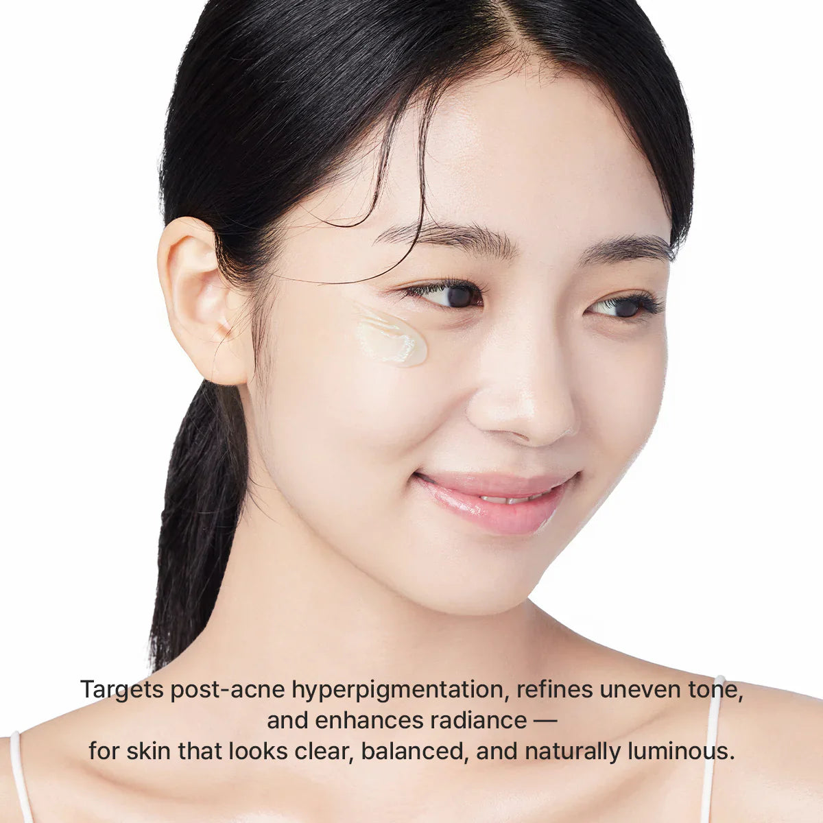 Woman with a cosmetic product on her face against a white background